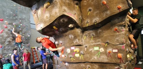 Students work their way up the climbing wall at the Student Recreation Center