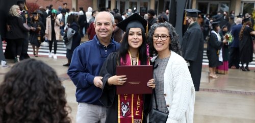 Parents celebrating graduation with their daughter